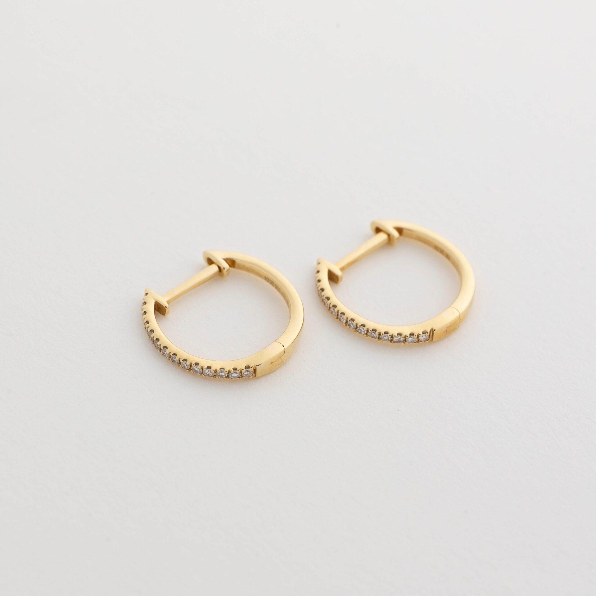 Victoria is a refined take on the everyday diamond hoop — light, modern, and effortlessly polished. Designed in 18kt yellow gold, this slim silhouette curves gently around the ear, offering a clean, understated line of sparkle through its delicate pavé diamonds.